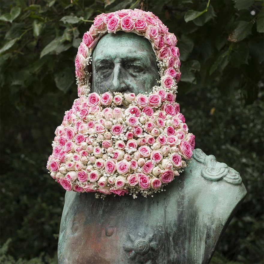Флорист украшает скульптуры бородами и коронами из цветов