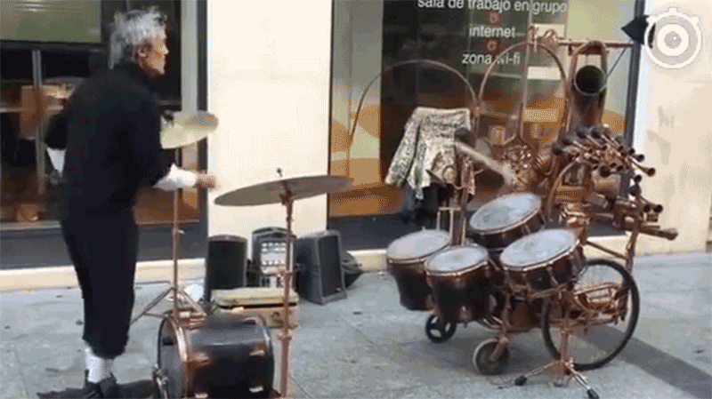 Необычный уличный музыкант жонглирует барабанными палочками